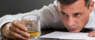 мужчина сидит за столом и смотрит на стакан с алкоголем в своей руке